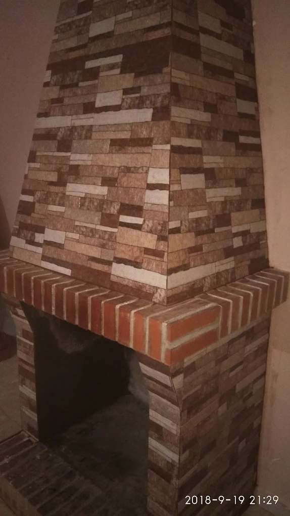 Chimenea con revestimiento de piedra natural y ladrillo visto en Madrid